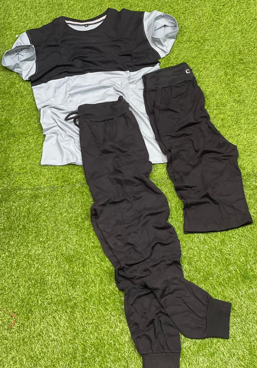 Black and grey short sleeve t-shirt with black jogger pants on green grass