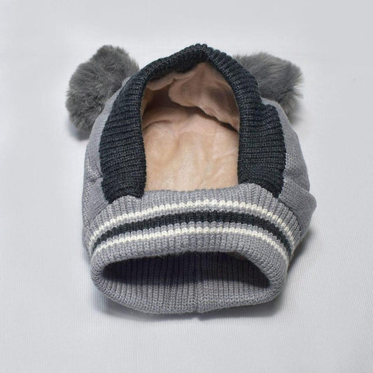Gray knit winter hat with ear flaps, striped trim, and fuzzy pom-pom ears on white background