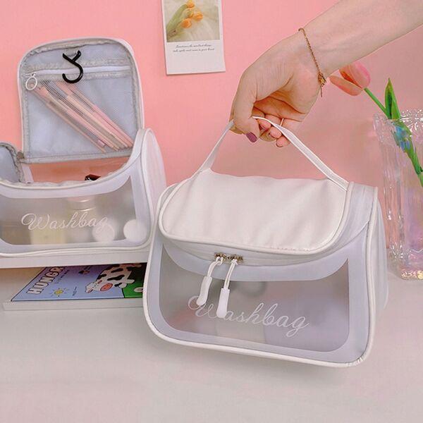 White transparent washbag cosmetic organizer with zipper and handle on pink background