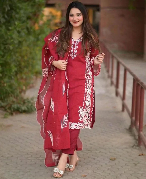 Woman wearing red 3-piece organza embroidered suit with white details outdoors