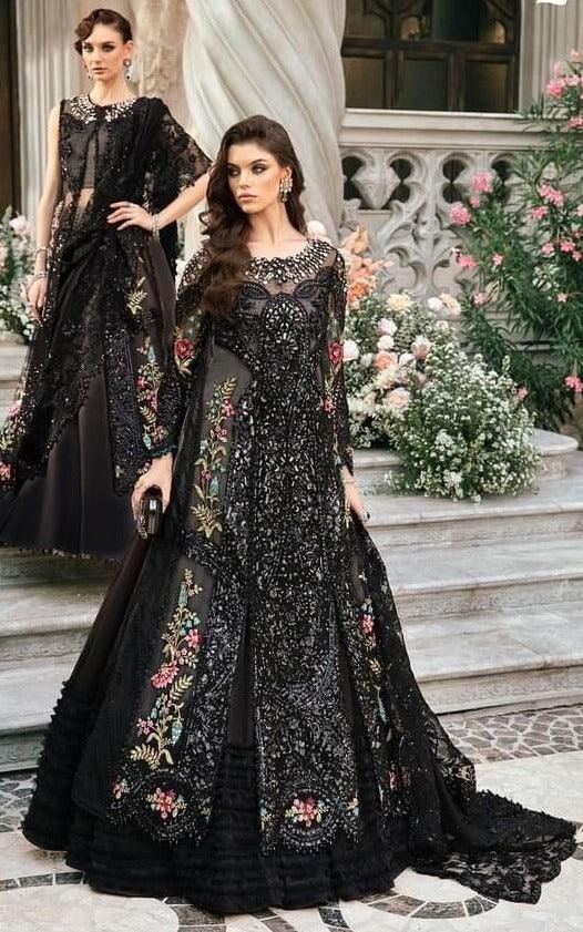 Women wearing black embroidered formal dresses with floral details on stone steps, outdoor setting