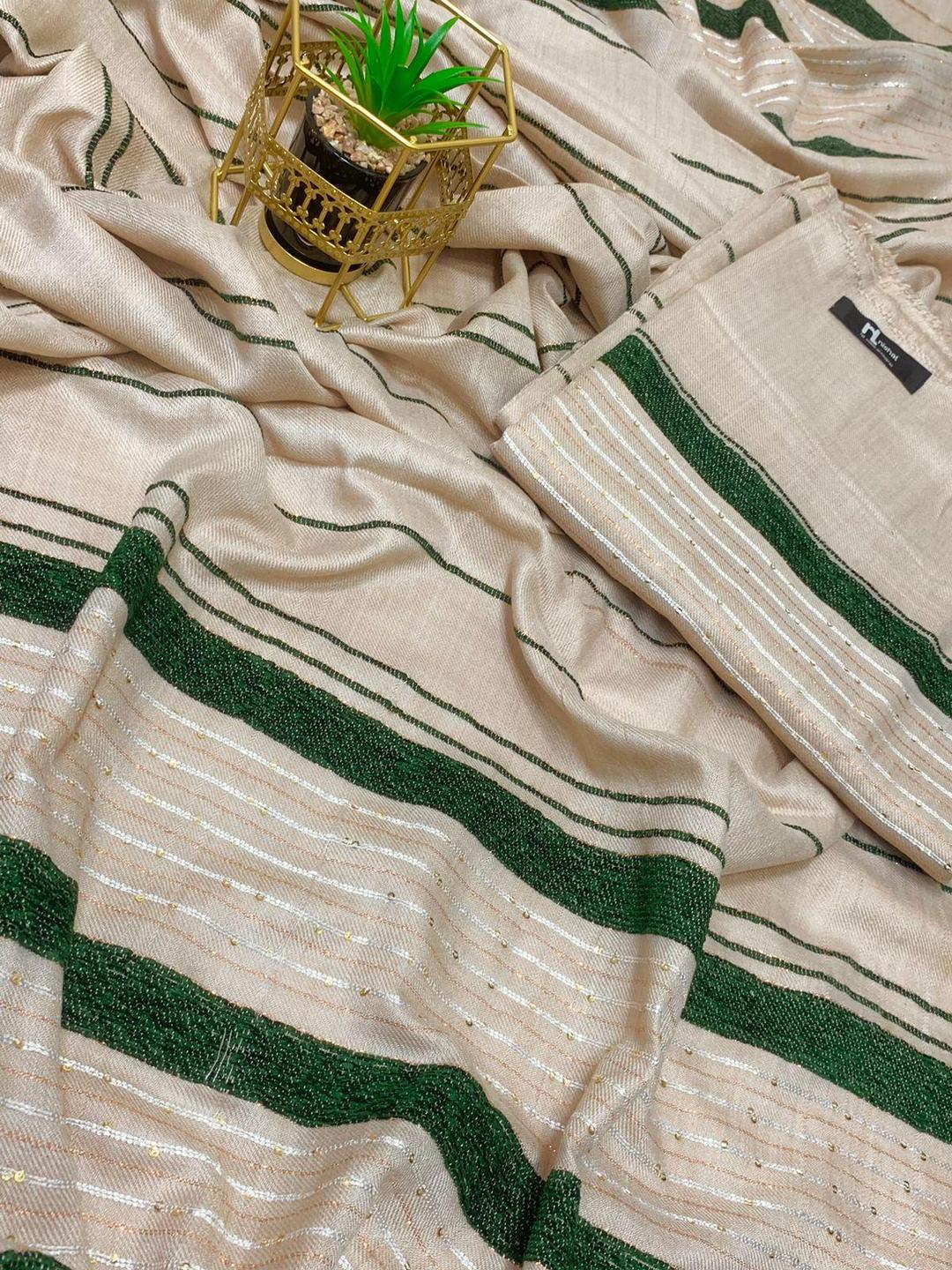 Beige saree with green and gold stripes, small potted plant on gold holder