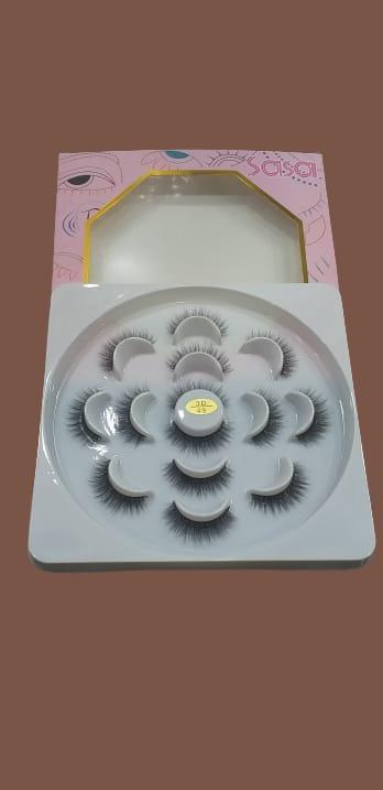 False eyelashes set in round packaging with pink box on brown background