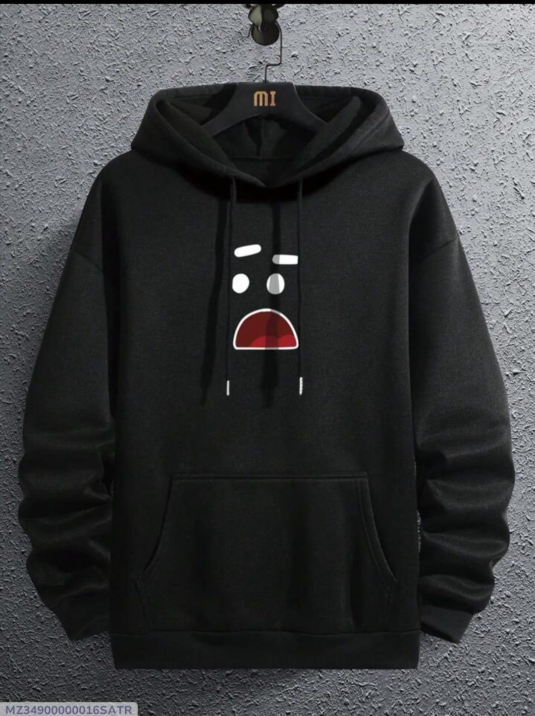 Black hoodie with a cartoon surprised face print, hanging on a textured gray wall