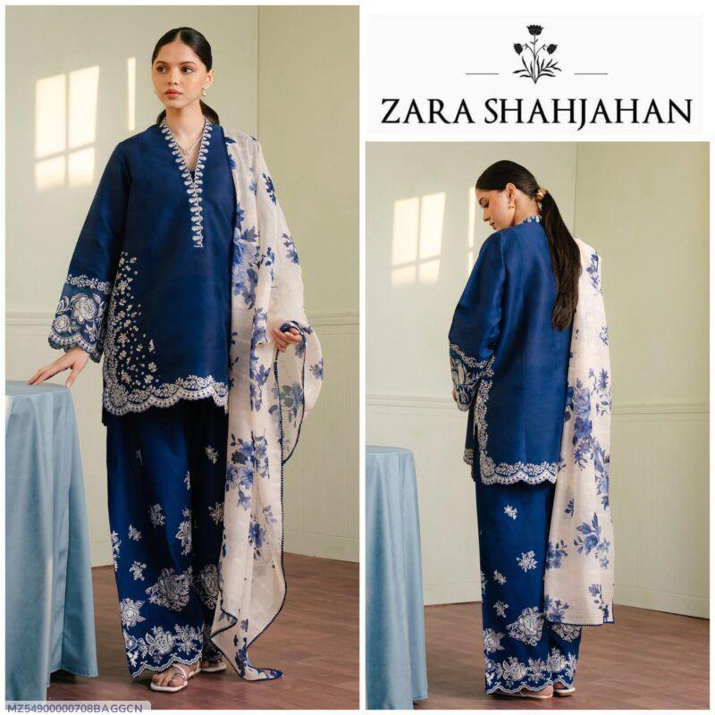Woman in navy blue embroidered Zara Shahjahan suit with floral dupatta, indoor setting