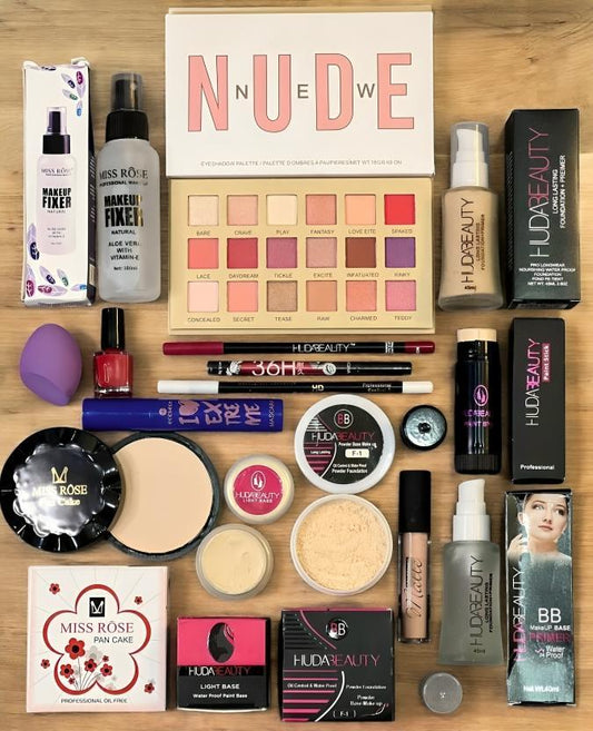 Makeup kit with nude eyeshadow palette, Huda Beauty products, face powders, and fixers on table