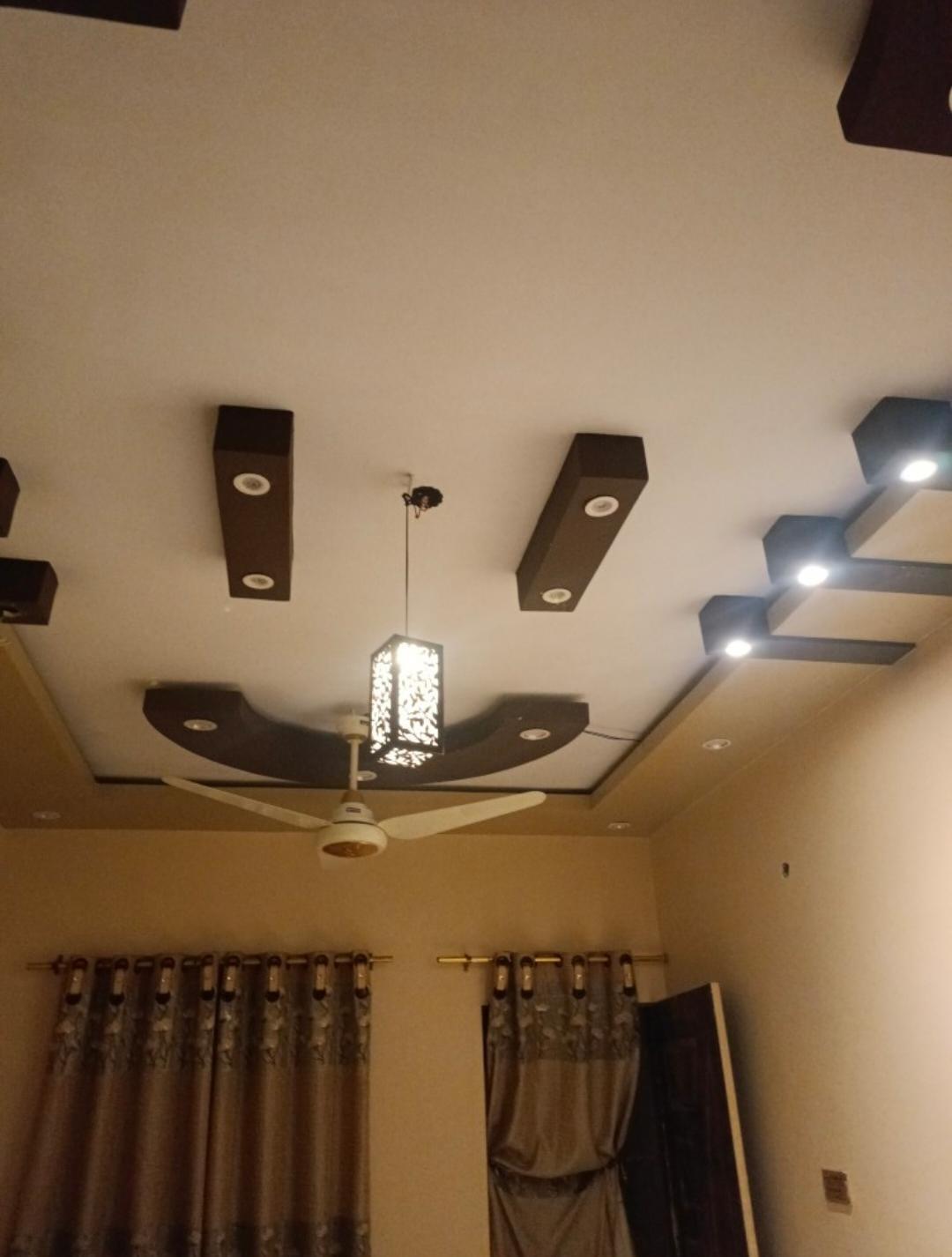 Modern living room ceiling with geometric lighting, fan, and decorative pendant light