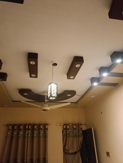 Modern living room ceiling with geometric lighting, fan, and decorative pendant light