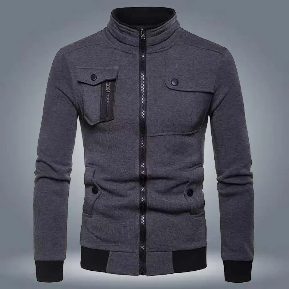 Dark grey zip up jacket with chest pockets and black cuffs on a plain background