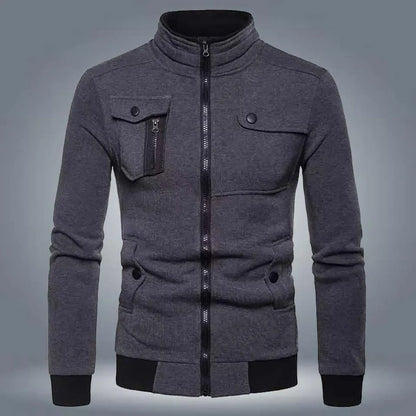 Dark grey zip up jacket with chest pockets and black cuffs on a plain background