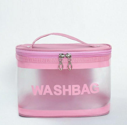 Pink transparent wash bag with zipper and handle on plain white background