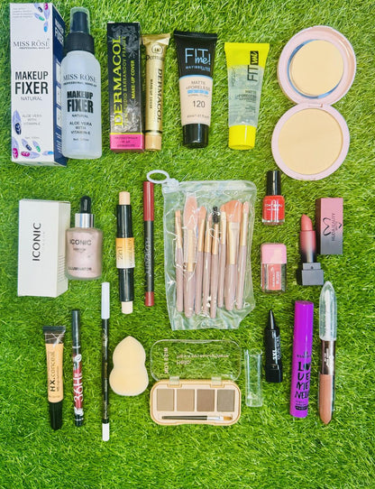 Assorted makeup products and brushes on green grass, including foundation, powder, and lipstick.
