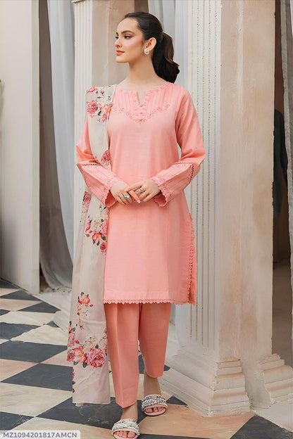 Woman wearing a peach pink embroidered salwar kameez with floral dupatta, standing indoors