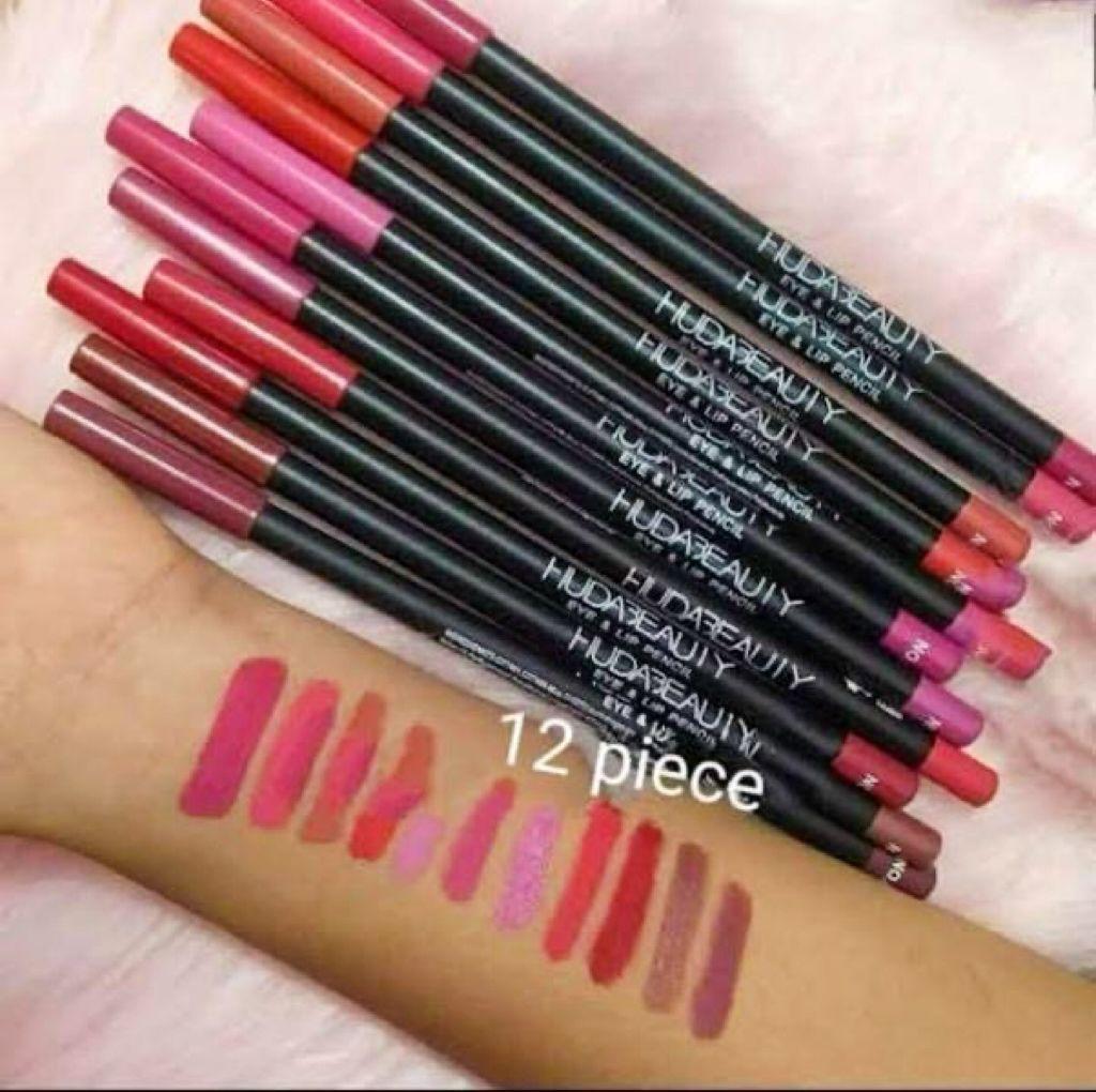 Huda Beauty 12 piece lip liner set with swatches on arm, assorted pink and red shades