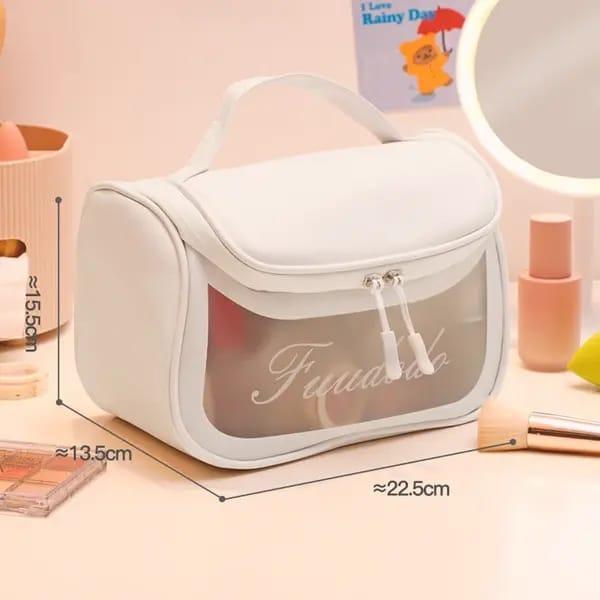 White travel makeup bag with clear front, zipper, handle, and size dimensions in a vanity setting