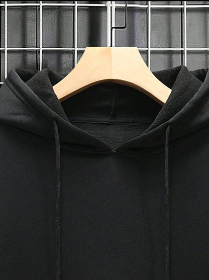 Black hoodie on wooden hanger against metal grid background