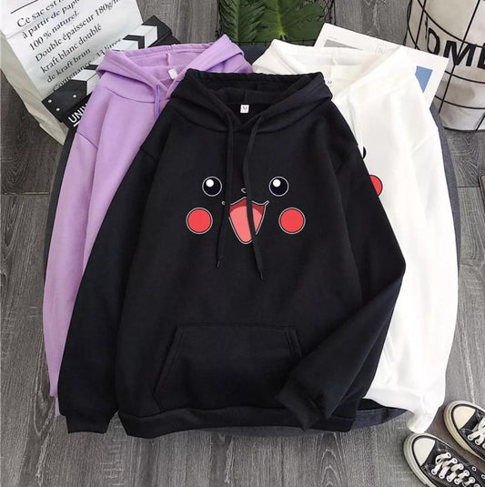 Three hoodies in black, purple, and white with a cute cartoon face, laid on wooden floor