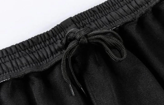 Black elastic waistband drawstring pants close-up on white background