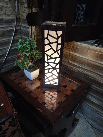Modern geometric table lamp with potted plant on wooden side table in cozy room