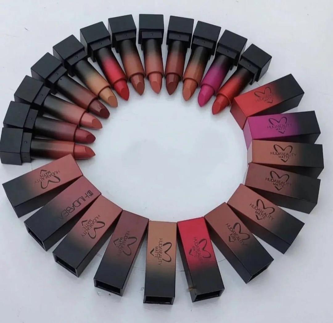 Huda Beauty matte lipsticks arranged in a semi-circle, showing various shades on a white background.